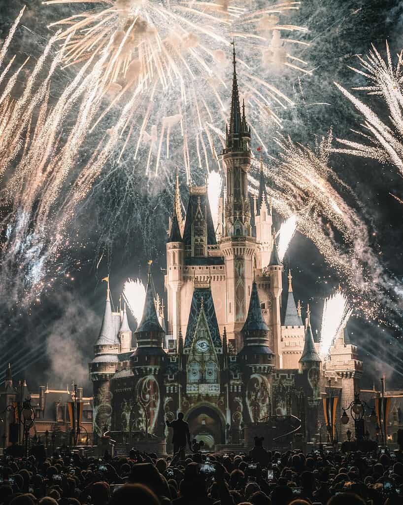 Enchanting night view of a famous castle illuminated by spectacular fireworks, capturing a magical ambiance.